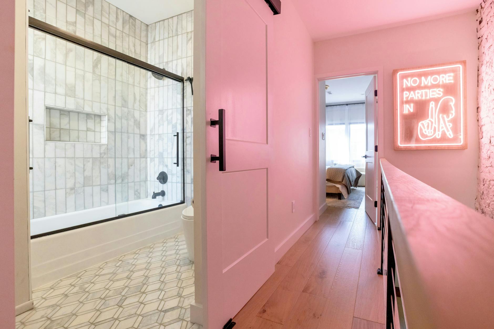 Nowoczesna łazienka w apartamencie z neonową dekoracją na ścianie