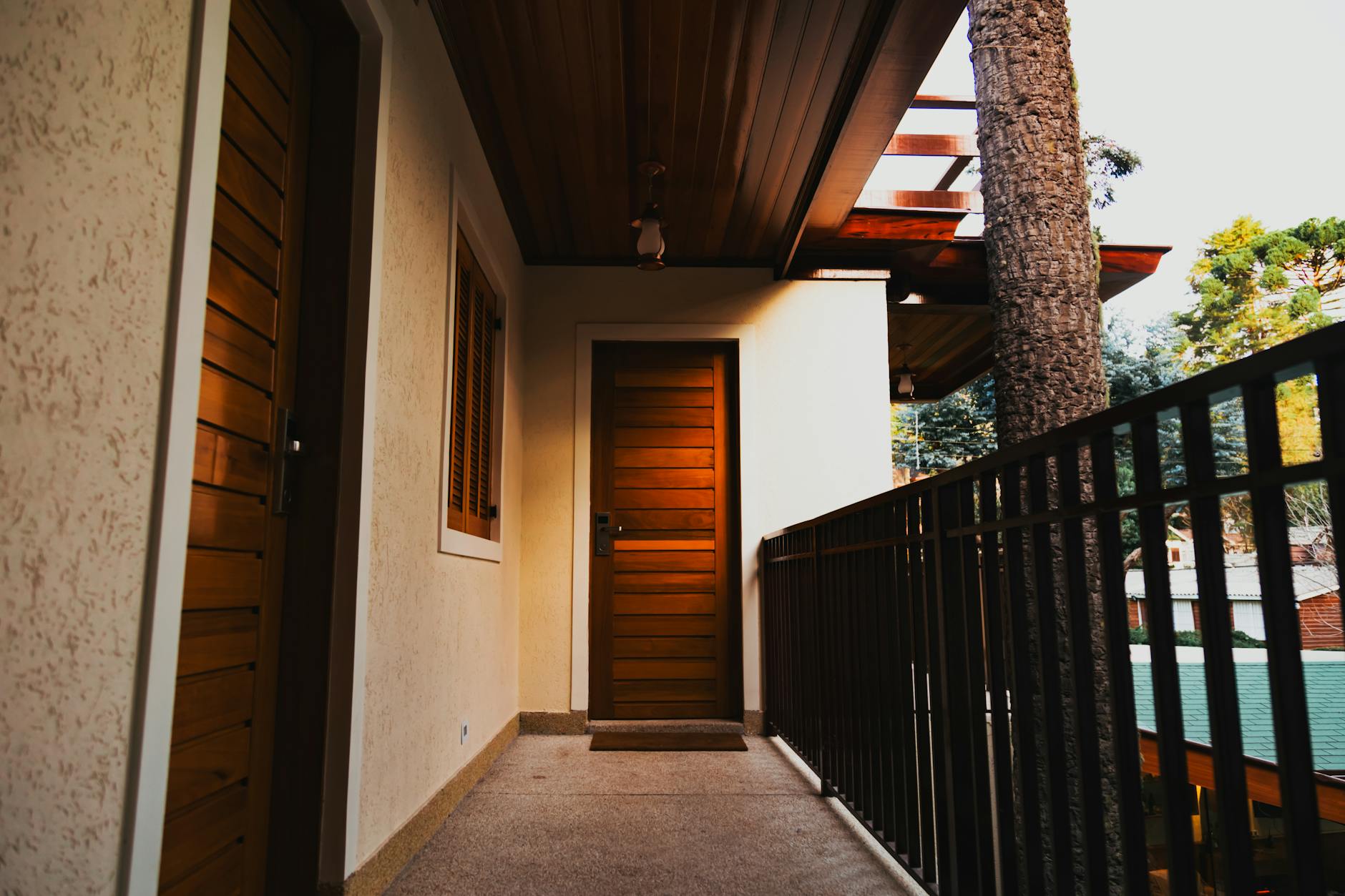 Nowoczesny balkon w bloku z przeszklonymi drewnianymi drzwiami wejściowymi