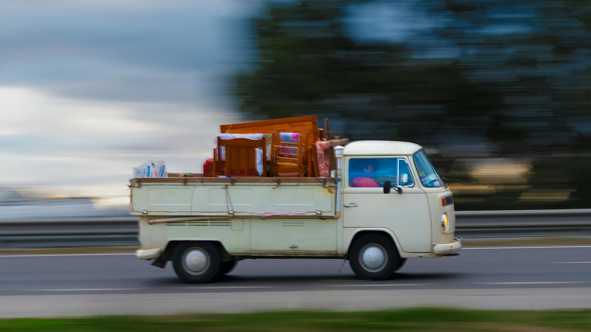 Stary bus z meblami jedzie autostradą podczas przeprowadzki